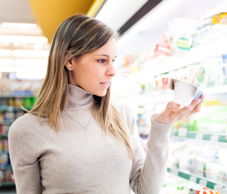 Young Blonde Woman Reading Nutrition Label